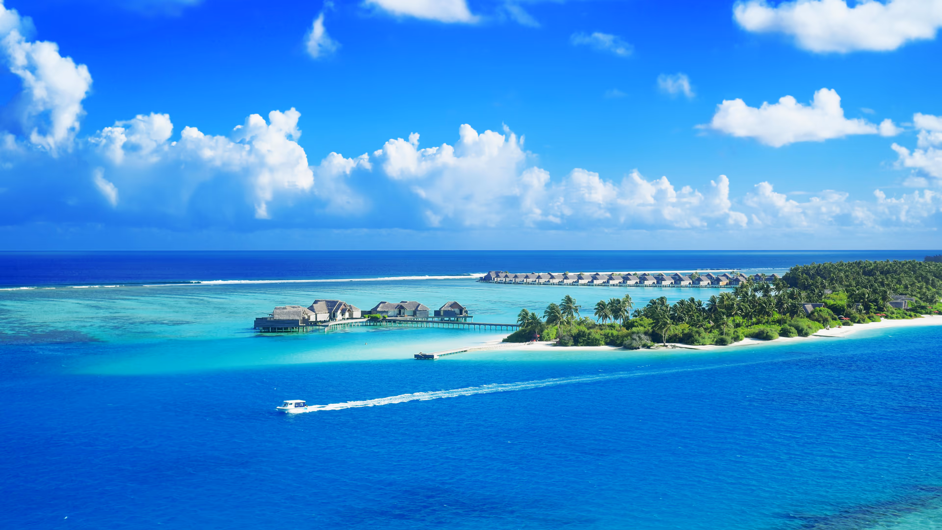 Crystal clear waters surround a luxurious Maldives resort under a bright blue sky - Image by Asad Photo Maldives from Pexels