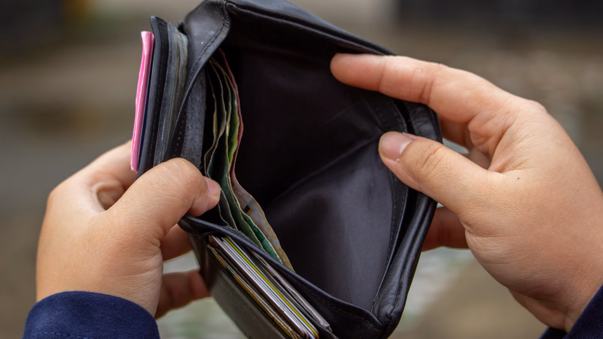 Hands holding an empty wallet, exploring themes of financial strain and budgeting - Image by Ahsanjaya from Pexels