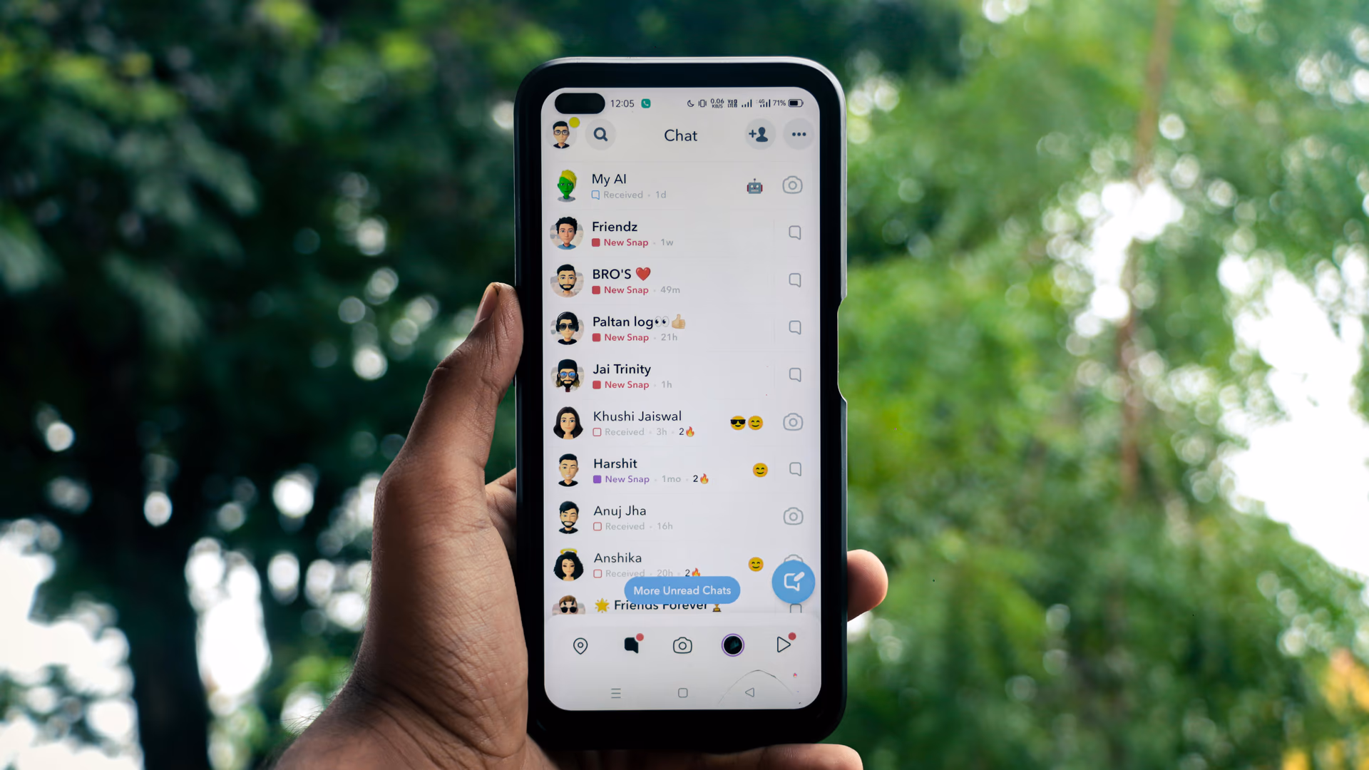 A hand holding a smartphone displaying a chat application outdoors against a green background - Image by Sanket Mishra from Pexels