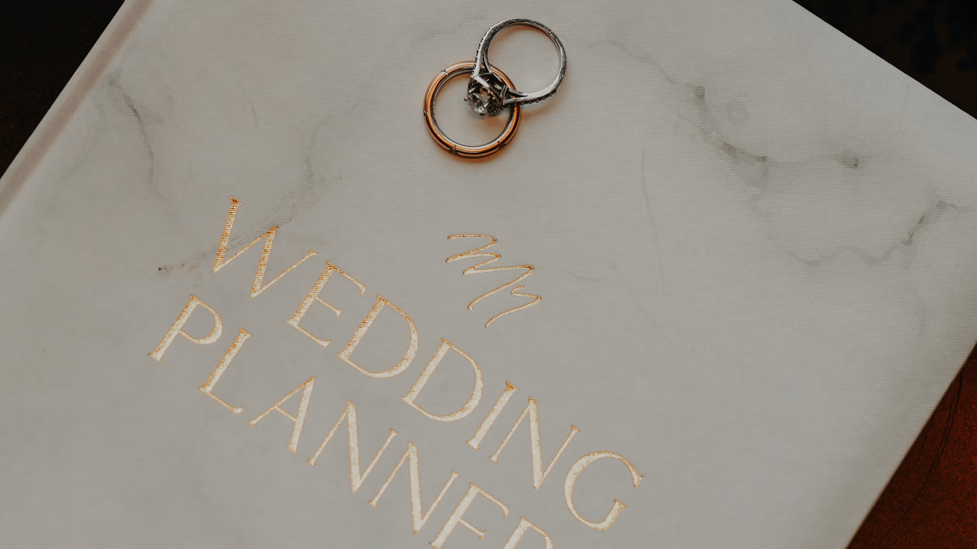 Close-up of a wedding planner book adorned with silver rings, symbolizing preparation and commitment - Image by Taha Samet Arslan from Pexels
