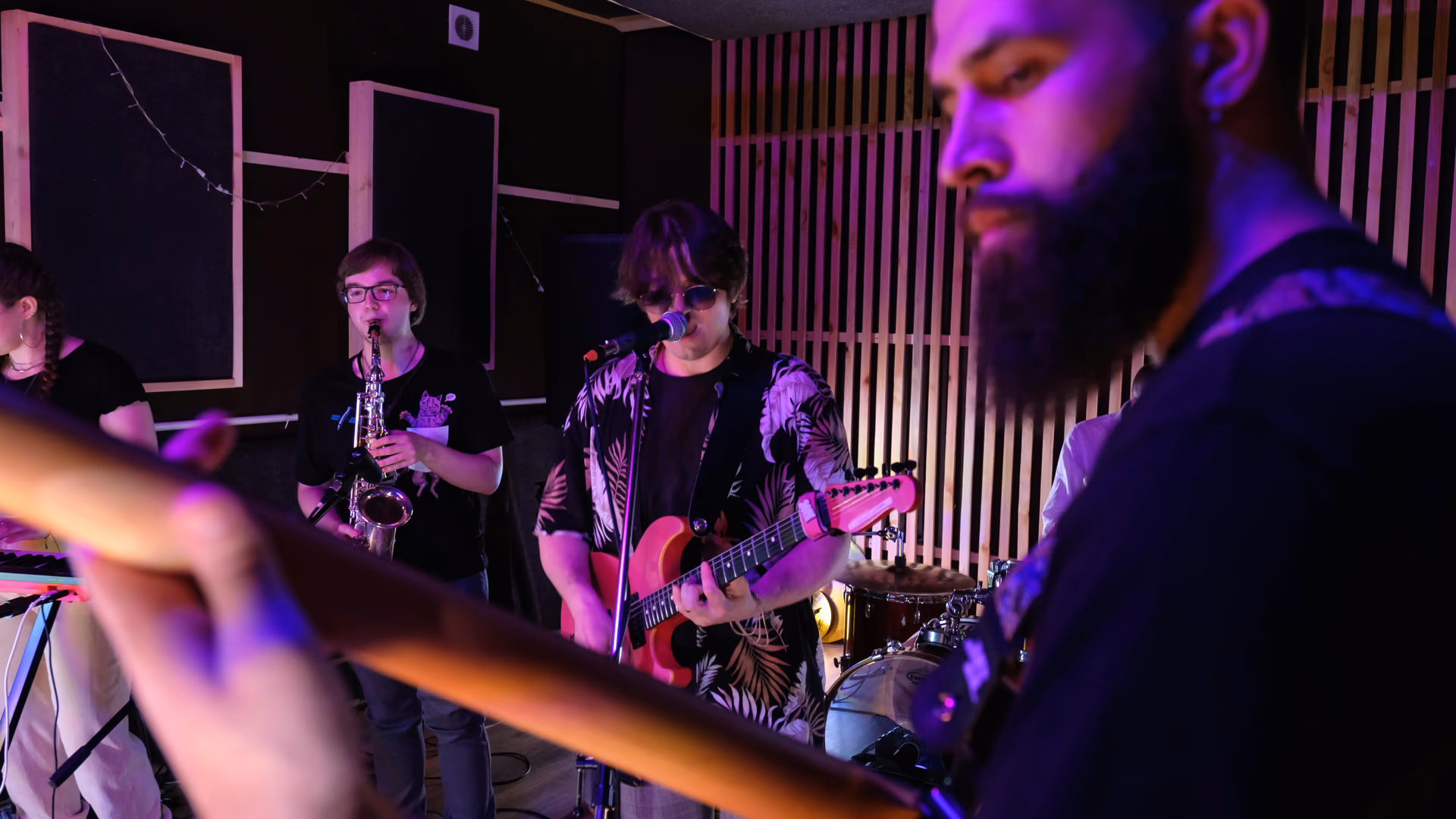 A vibrant band performing in a studio with various musical instruments under colorful lights - Image by Big Bag Films from Pexels