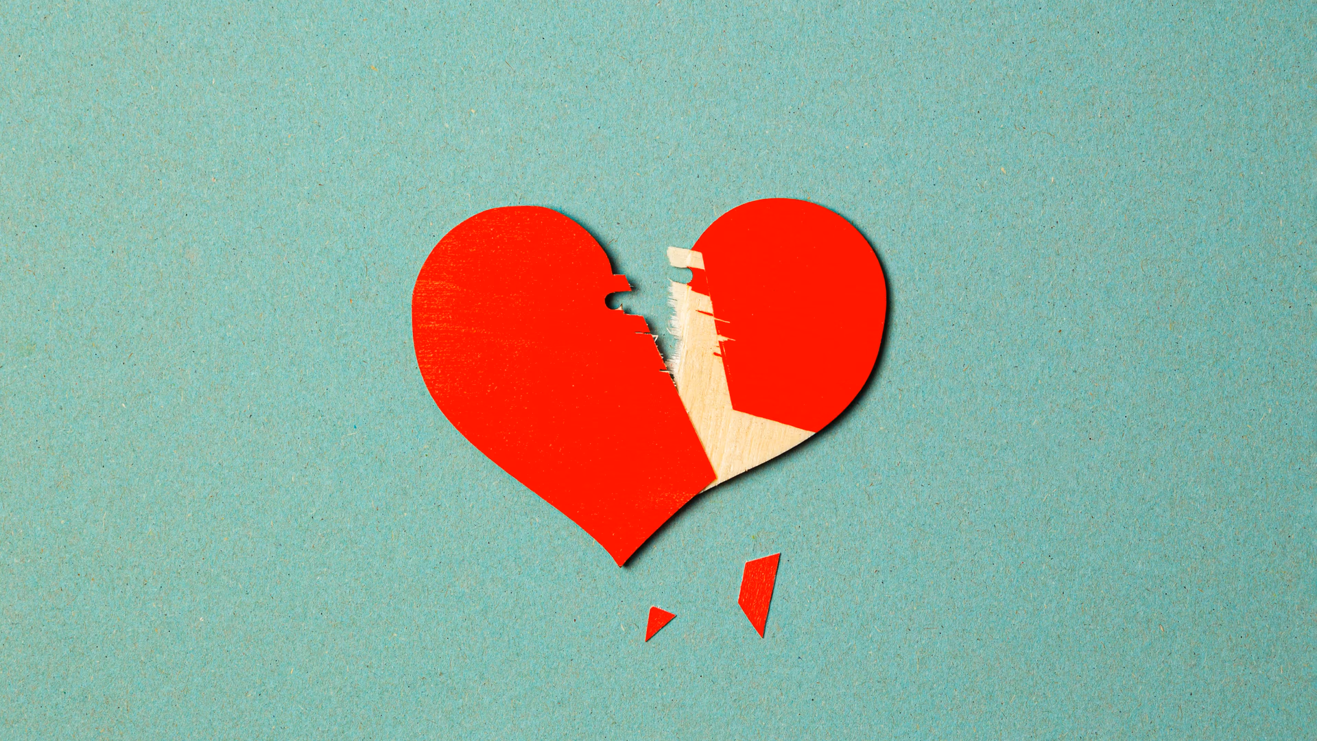 A torn red paper heart on a blue background symbolizes broken love or heartache - Image by Stas Knop from Pexels