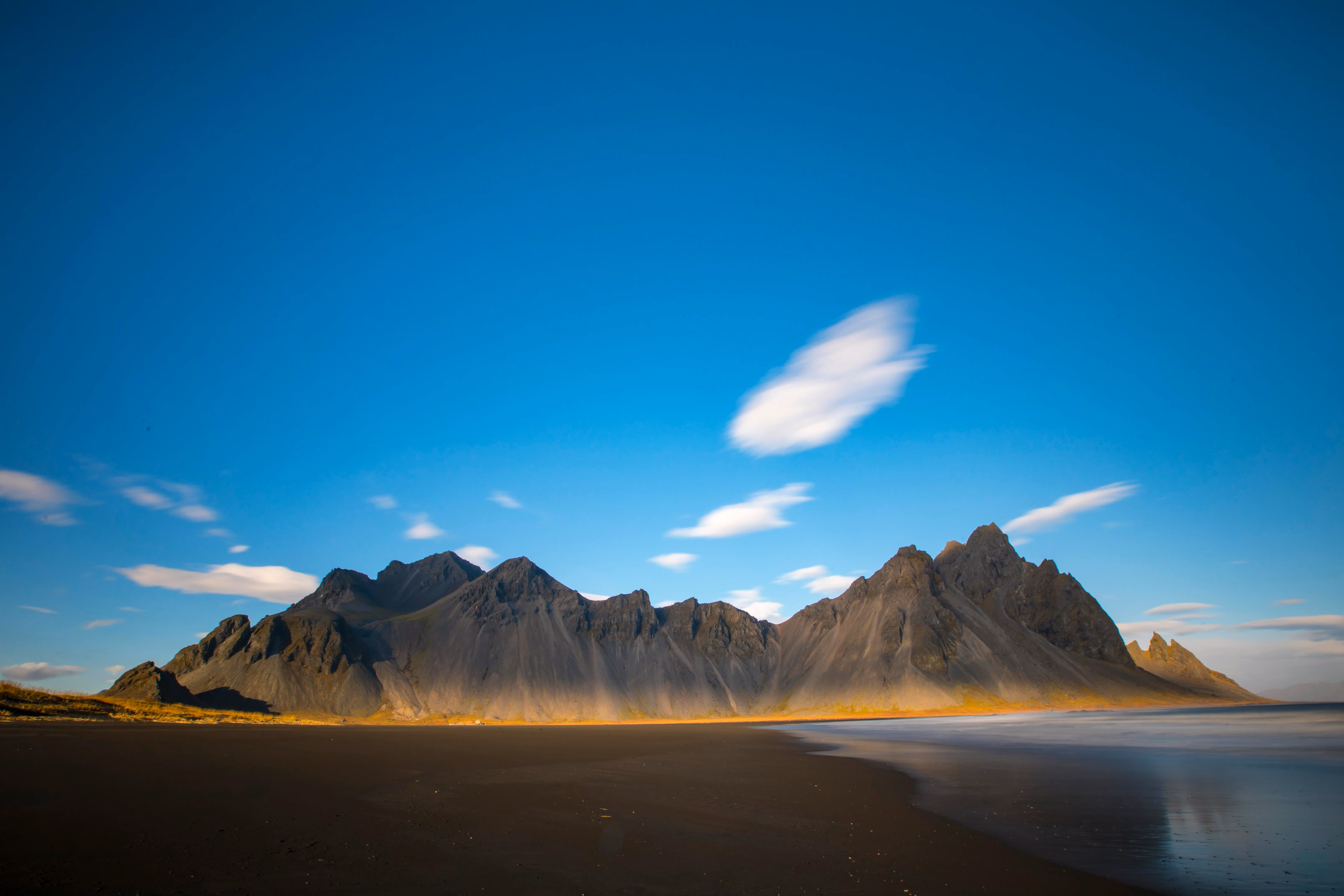 Majestic view of Vestrahorn Mountain with black sand beach under a bright blue sky - Image by Stephen Leonardi from Pexels
