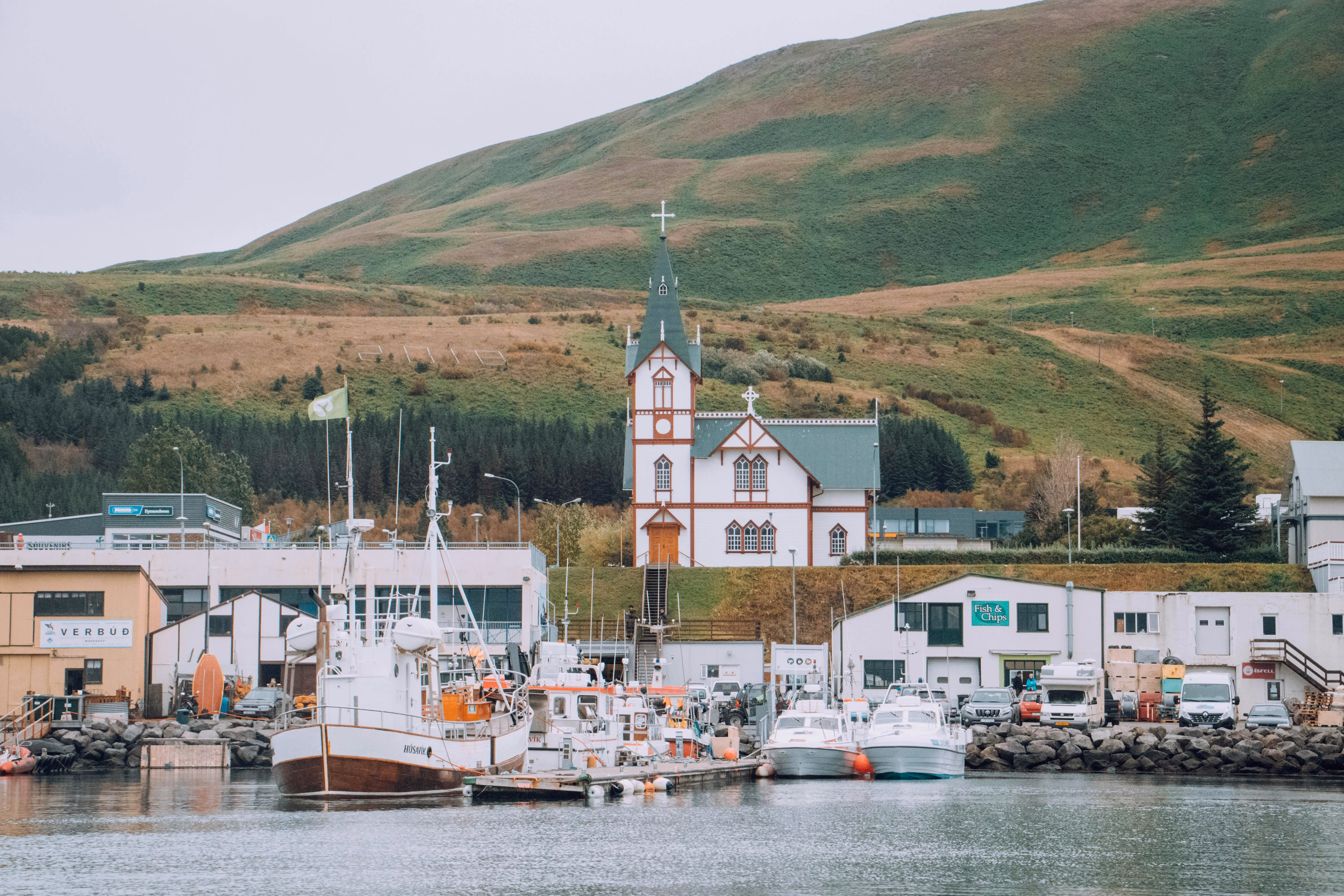Charming harbor scene with classic church and boats in Húsavík, Iceland - Image by Joan Costa from Pexels